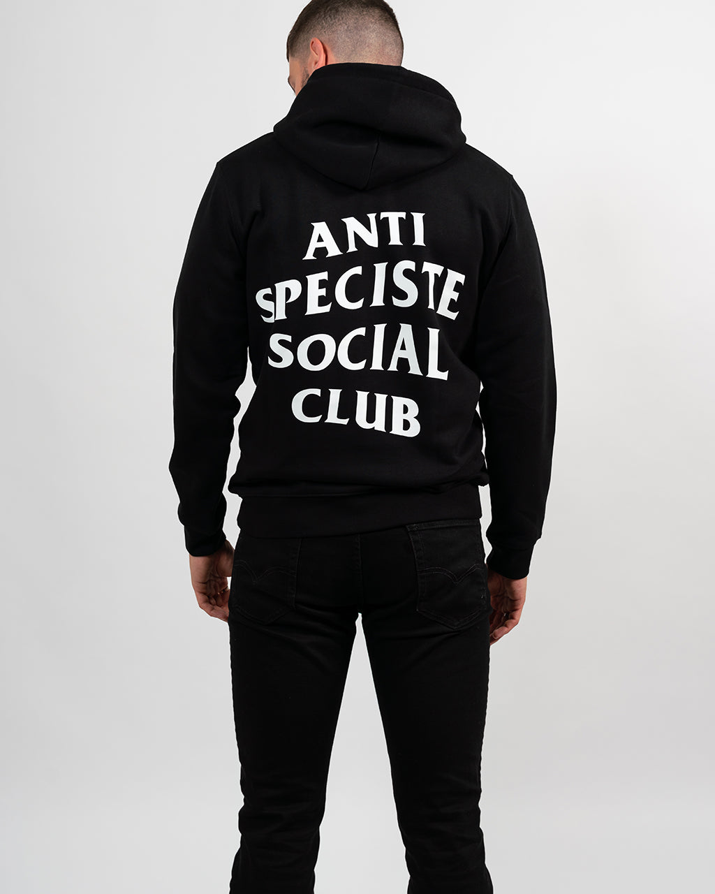 Mannequin homme de dos portant un hoodie noir avec une sérigraphie blanche Anti Spéciste Social Club.