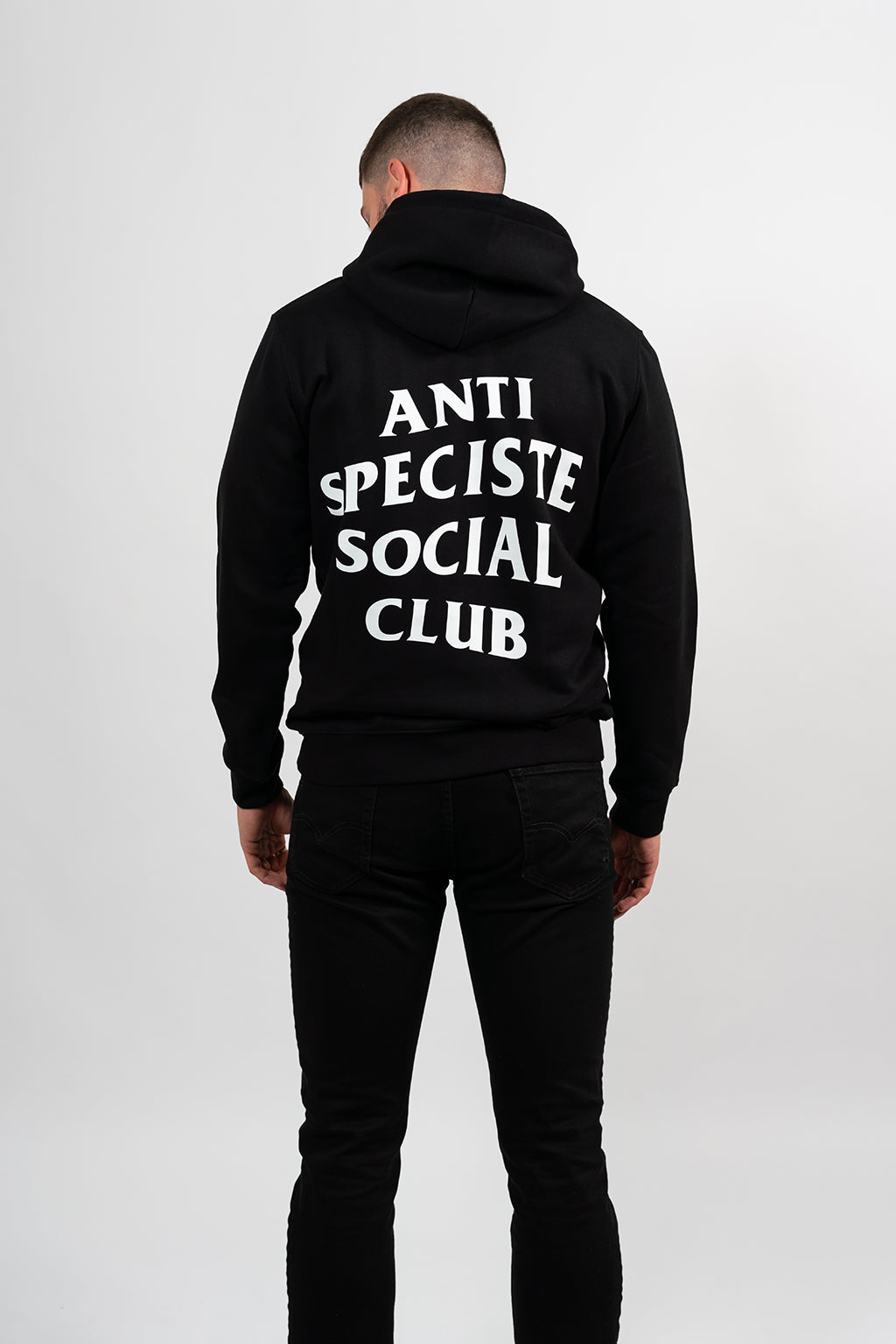 Mannequin homme de dos portant un hoodie noir avec une sérigraphie blanche Anti Spéciste Social Club.