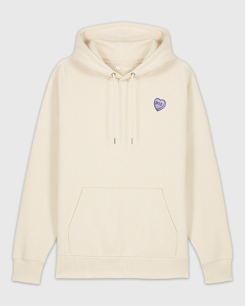 Hoodie beige avec une broderie mauve en forme de comprimé de B12 en coeur.