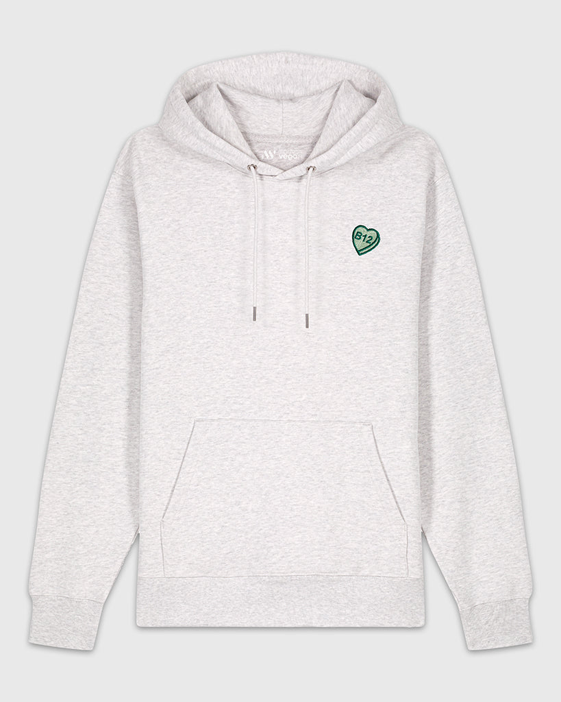 Hoodie gris clair chiné avec une broderie verte en forme de comprimé de B12 en coeur.