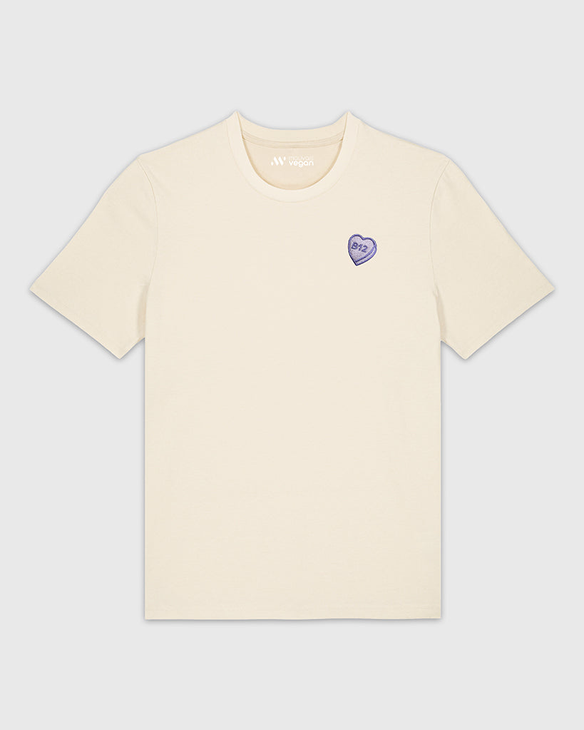 T-shirt beige avec une broderie mauve en forme de comprimé de B12 en coeur.