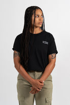 Mannequin femme portant un t-shirt noir avec une broderie blanche Bouffeuse de graines.