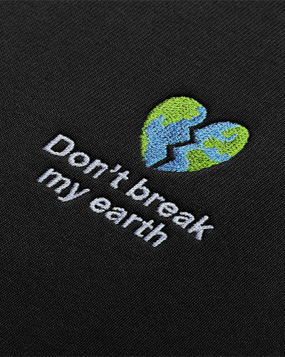 Détail de la broderie Don’t break my earth représentant une planète en forme de coeur brisé.
