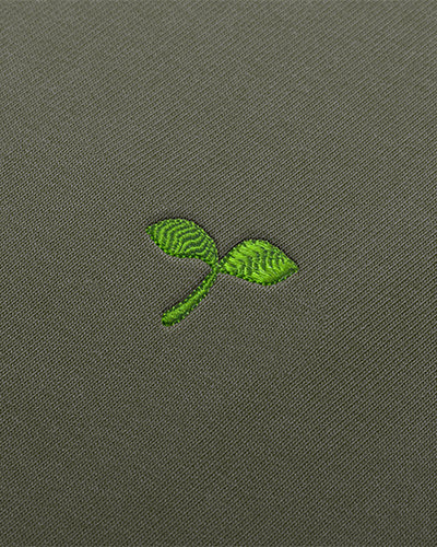 Détail de la broderie représentant un emoji pousse vert.