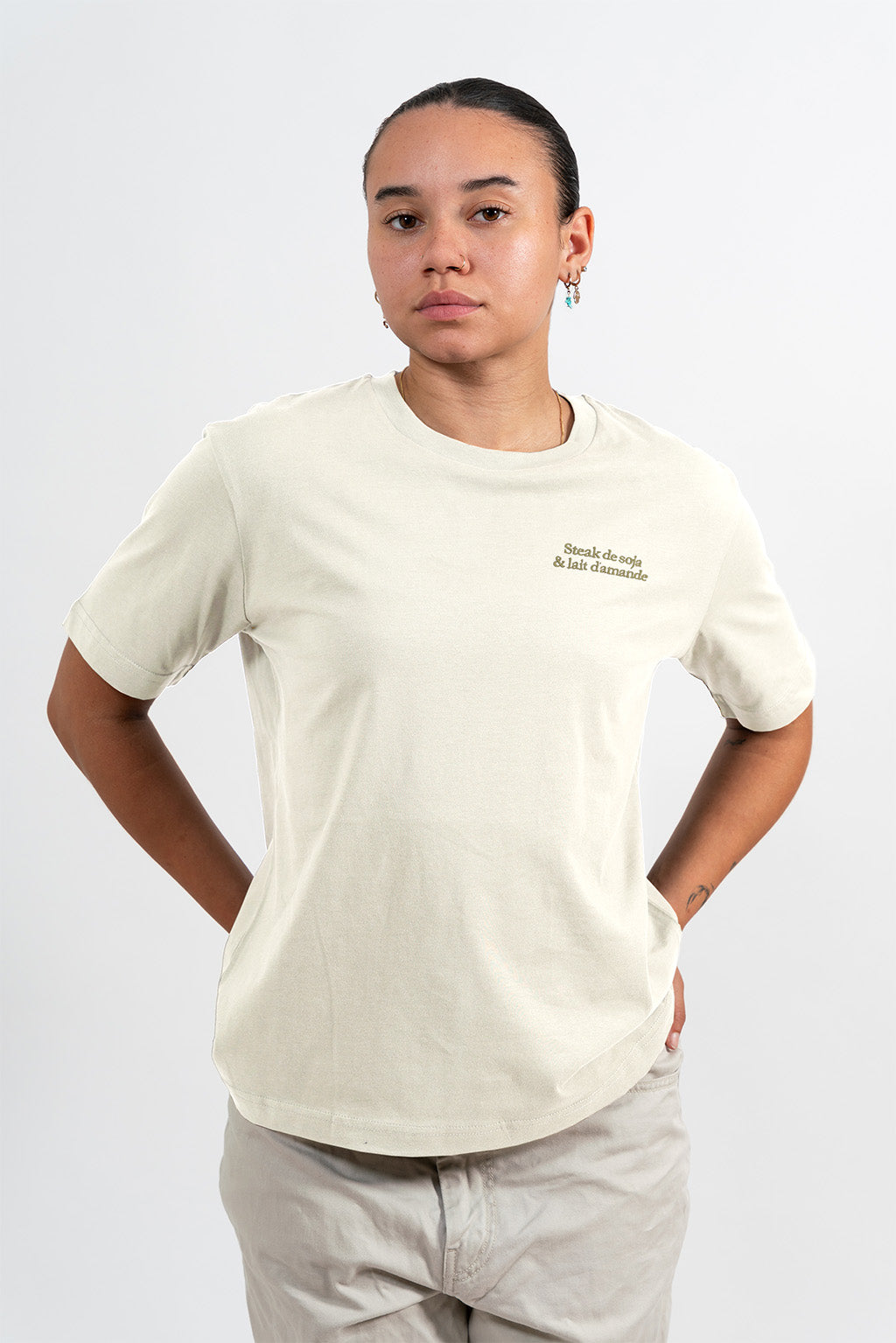 Mannequin femme portant un t-shirt beige avec une broderie khaki Steak de soja et lait d’amande. 