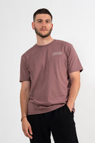 Mannequin homme portant un t-shirt vieux rose avec une broderie blanche Steak de soja et lait d’amande. 