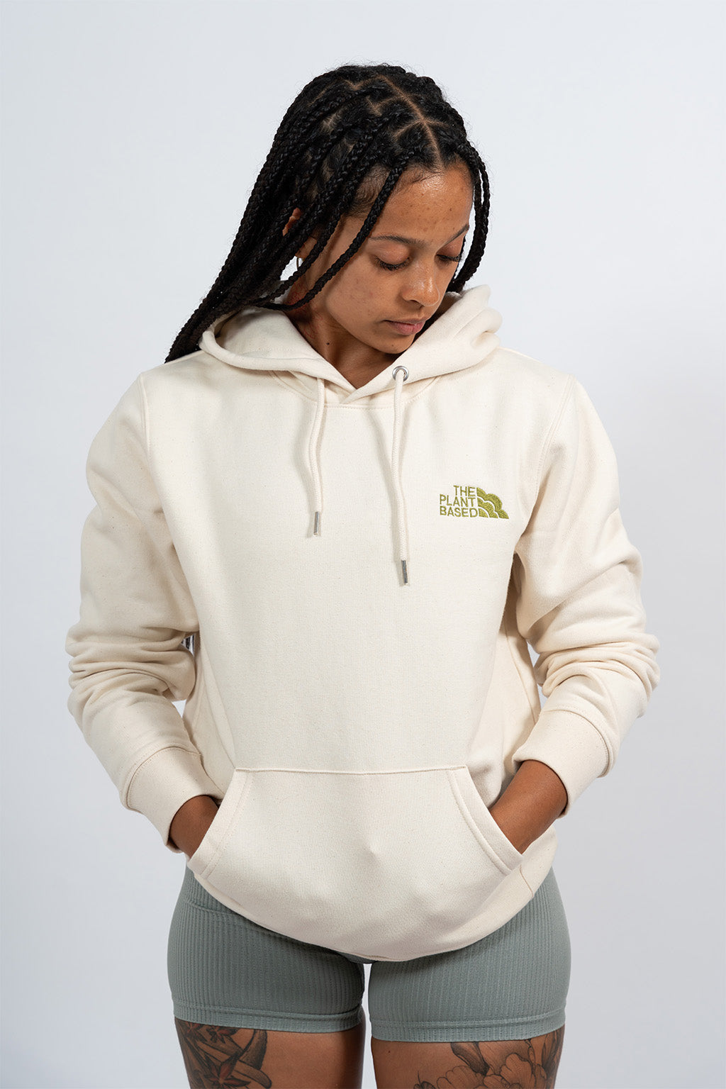 Mannequin femme portant un hoodie beige avec une broderie khaki The Plant Based.