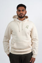 Mannequin homme portant un hoodie beige avec une broderie khaki représentant 3 visages d’animaux.